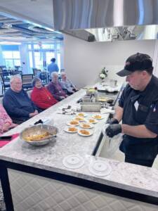 Food Services Director Anthony Ribaudo puts on a cooking demo for residents at The Chelsea at Washington Township Assisted Living and Memory Care community in Bergen County, NJ.