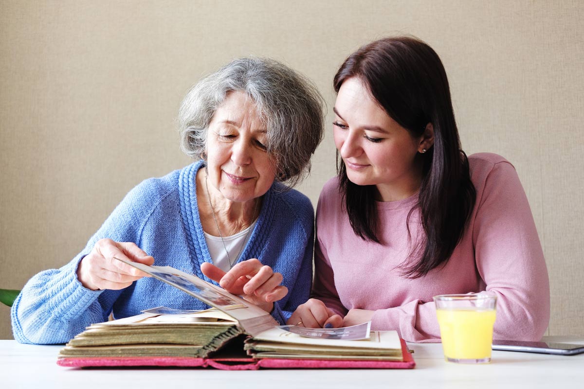 Grandmother and daughter watching a family album with old photos together